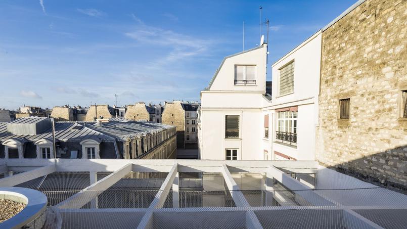 découvrez la métamorphose urbaine à paris avec la transformation d'un garage des années 1930 en un immeuble résidentiel moderne alliant charme historique et confort contemporain.